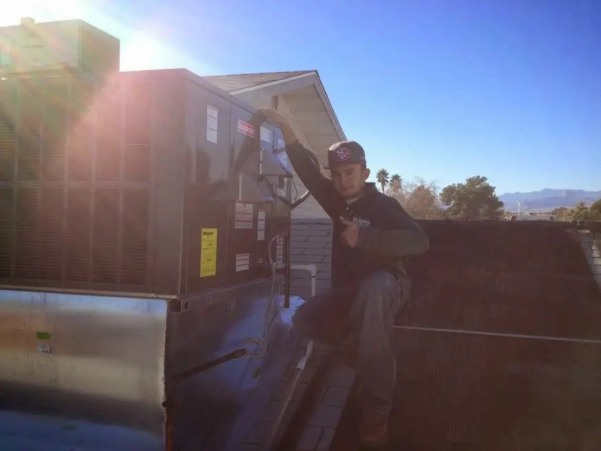 HVAC technician performing Boiler Repair on a rooftop unit in Clover